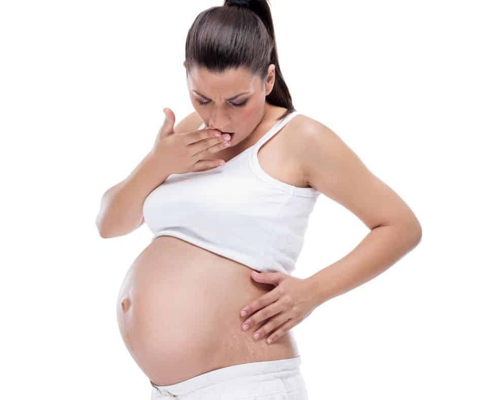 pregnant woman looking at stretch marks on her belly