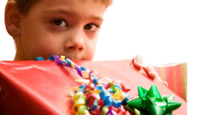 A 3 year old boy holding a gift